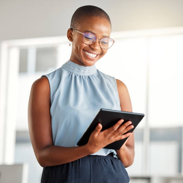 A Black woman professional smiling at a desk in a bright office setting